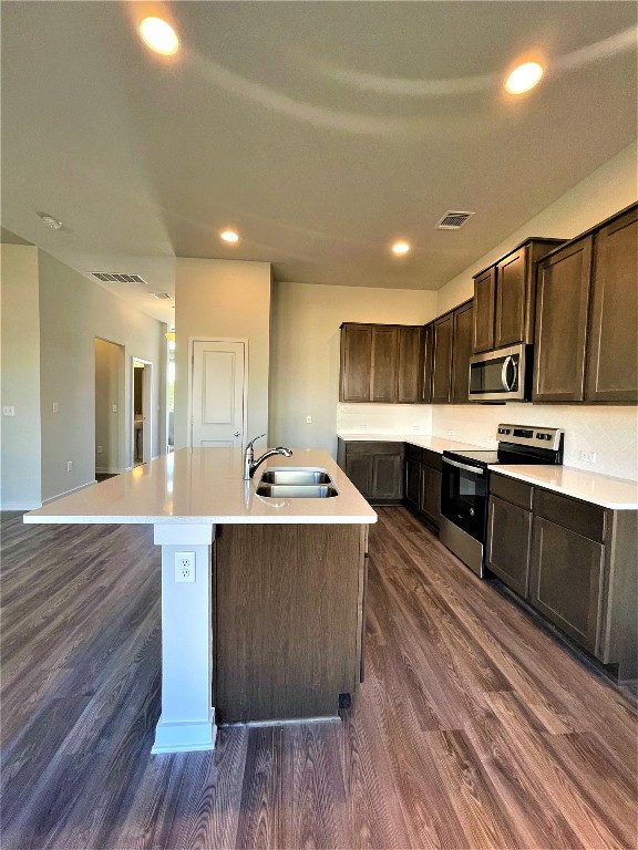 15110 Forum Avenue Pflugerville, TX 78660 - Photo 8 of 29 a large kitchen with stainless steel appliances wooden floors and wooden cabinets