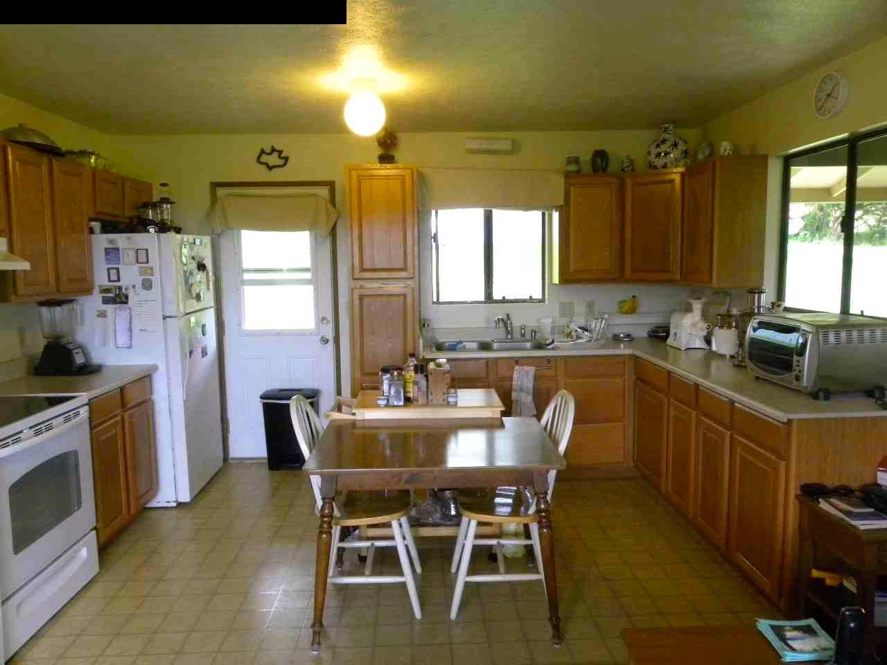 305 Kaupakalua Road Haiku, HI 96708 - Photo 6 of 13 a kitchen with a table chairs sink and cabinets