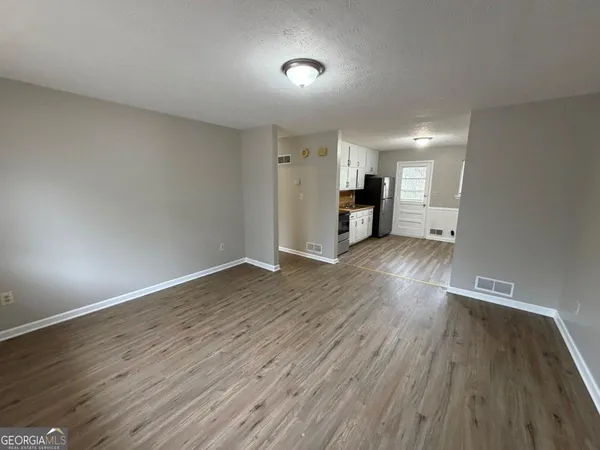 a view of empty room with wooden floor