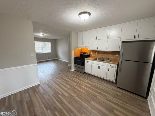 a kitchen with stainless steel appliances a refrigerator sink and cabinets