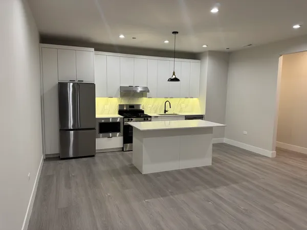 a kitchen with stainless steel appliances granite countertop a refrigerator a stove and a sink