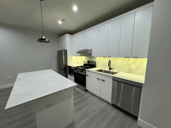 a kitchen with a sink cabinets and wooden floor