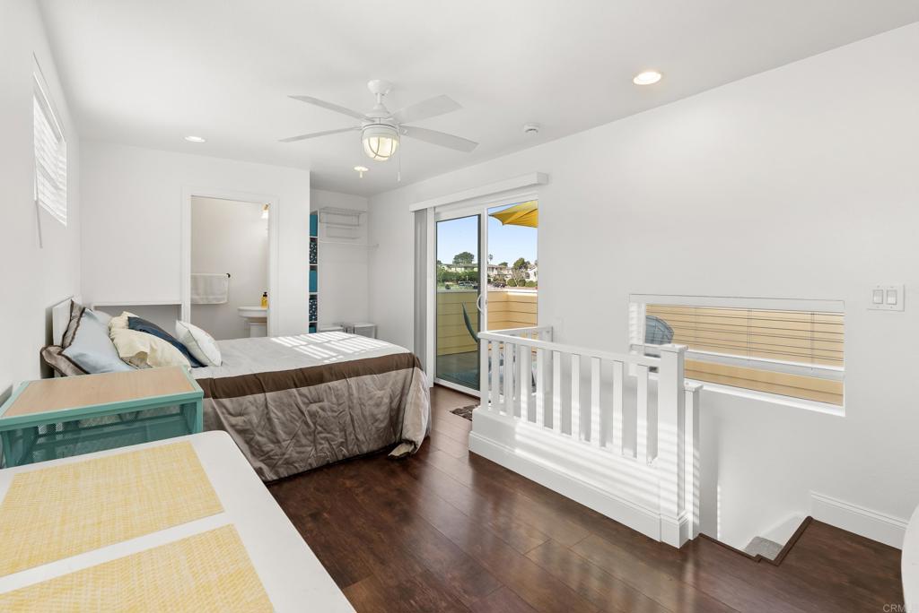 1624 North Coast Highway 101, Unit 2 Encinitas, CA 92024 - Photo 19 of 43 a bedroom with a bed and a table with wooden floor