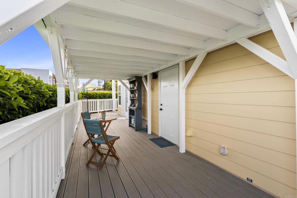 1624 North Coast Highway 101, Unit 2 Encinitas, CA 92024 - Photo 32 of 43 a view of a chairs and table in patio with wooden fence