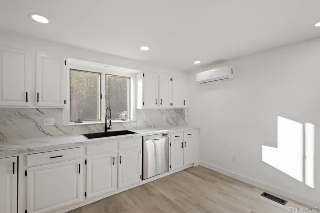 a kitchen with granite countertop white cabinets and a sink
