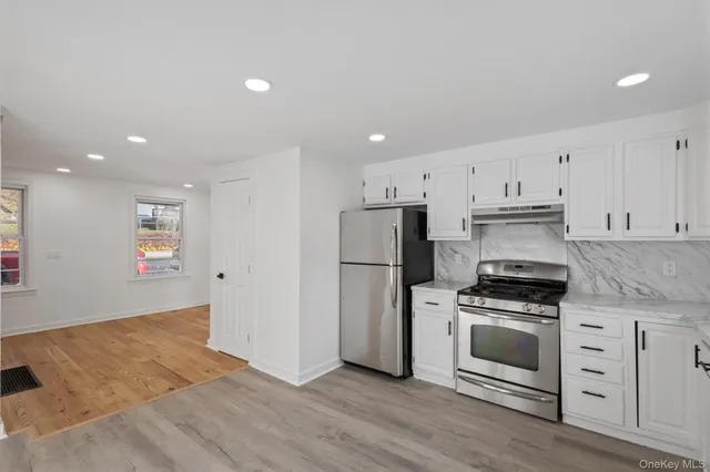 a kitchen with white cabinets and stainless steel appliances