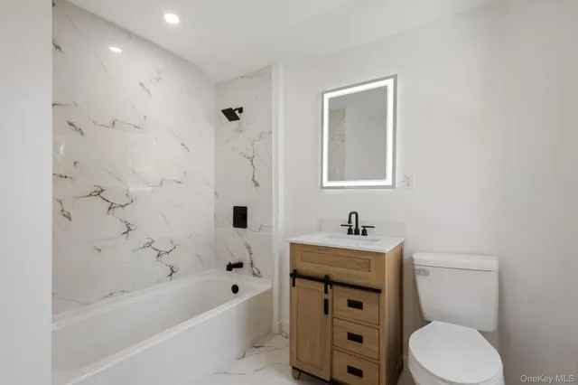 a bathroom with a sink toilet vanity and bathtub