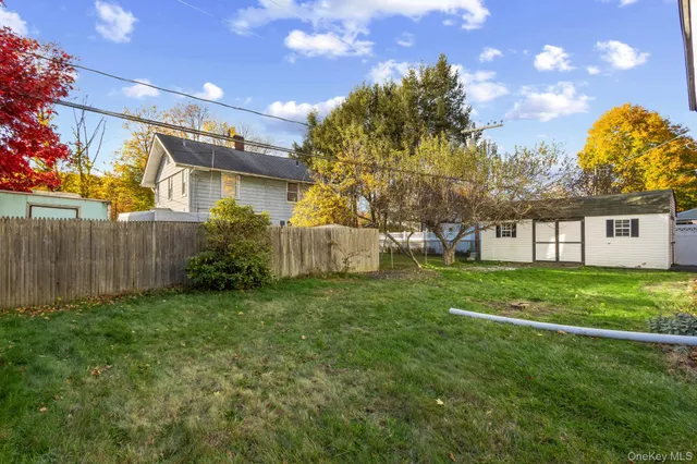 a view of a house with a big yard and a large tree