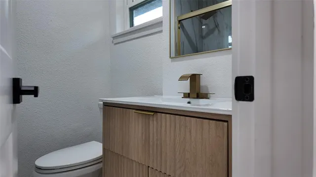 a bathroom with a toilet a sink and mirror