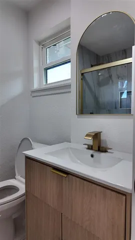 a bathroom with a sink a toilet and a mirror