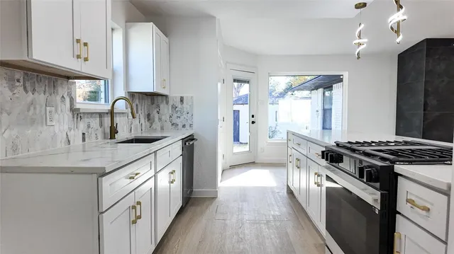 a kitchen with stainless steel appliances granite countertop a sink stove and refrigerator