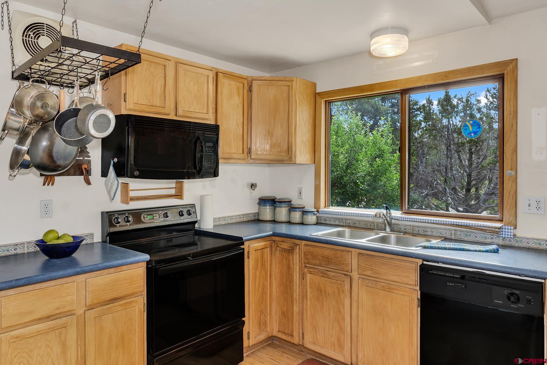 20327 Ward Creek Road Cedaredge, CO 81413 - Photo 15 of 35 a kitchen with stainless steel appliances a sink a stove a microwave a refrigerator a sink and cabinets