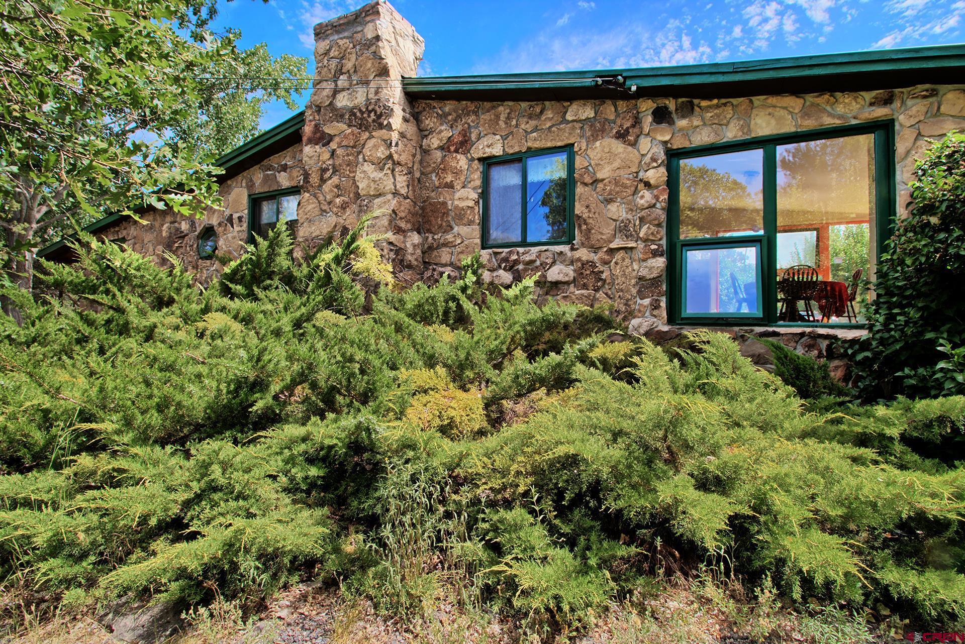 20327 Ward Creek Road Cedaredge, CO 81413 - Photo 6 of 35 a view of a stone house with a small yard