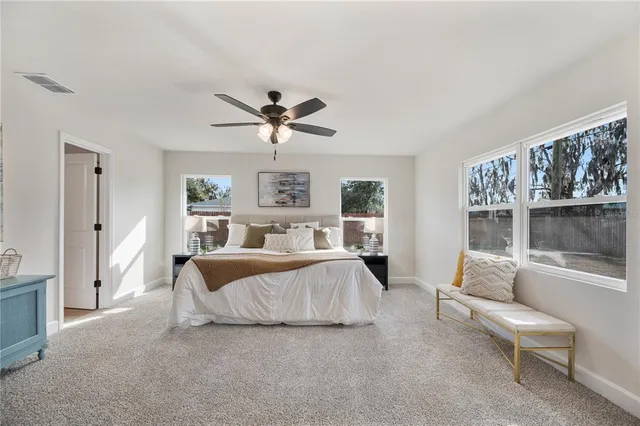 a spacious bedroom with a bed a couch and a window