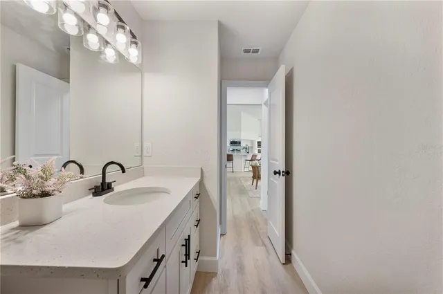 an entryway with wooden floor and a mirror