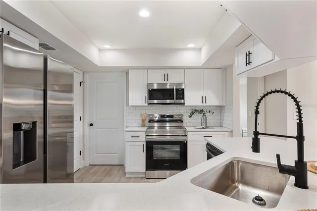 a kitchen with a sink stainless steel appliances and cabinets