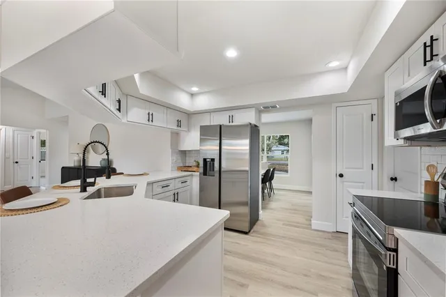 a kitchen with stainless steel appliances a refrigerator stove microwave and sink