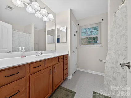 a spacious bathroom with a double vanity sink a large mirror and a shower