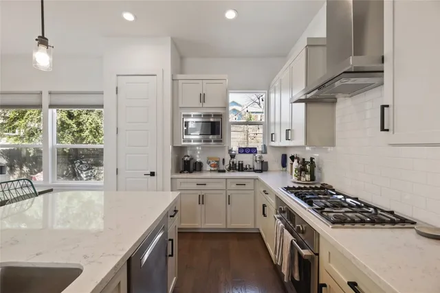 a kitchen with stainless steel appliances granite countertop a sink stove and refrigerator