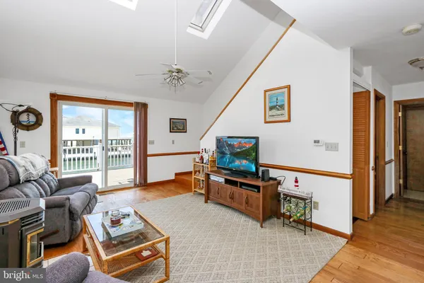 a living room with furniture a flat screen tv and a window