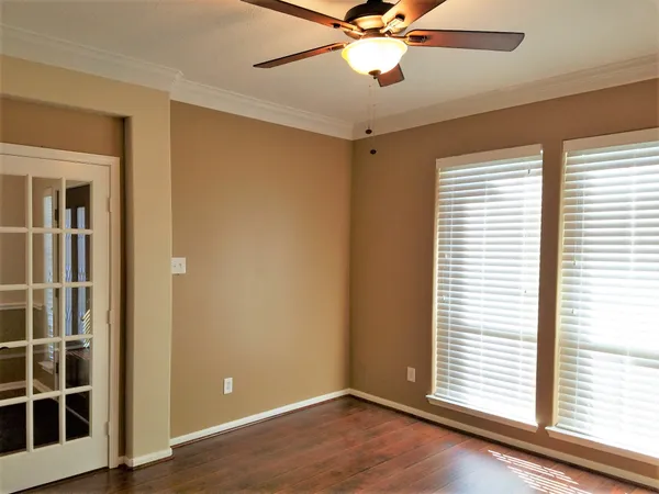 a dining room with wooden floor a chandelier a glass table and chairs