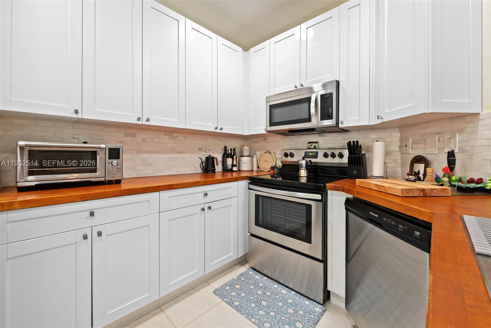 16634 Southwest 79th Terrace Miami, FL 33193 - Photo 10 of 25 a kitchen with stainless steel appliances granite countertop a sink and a stove