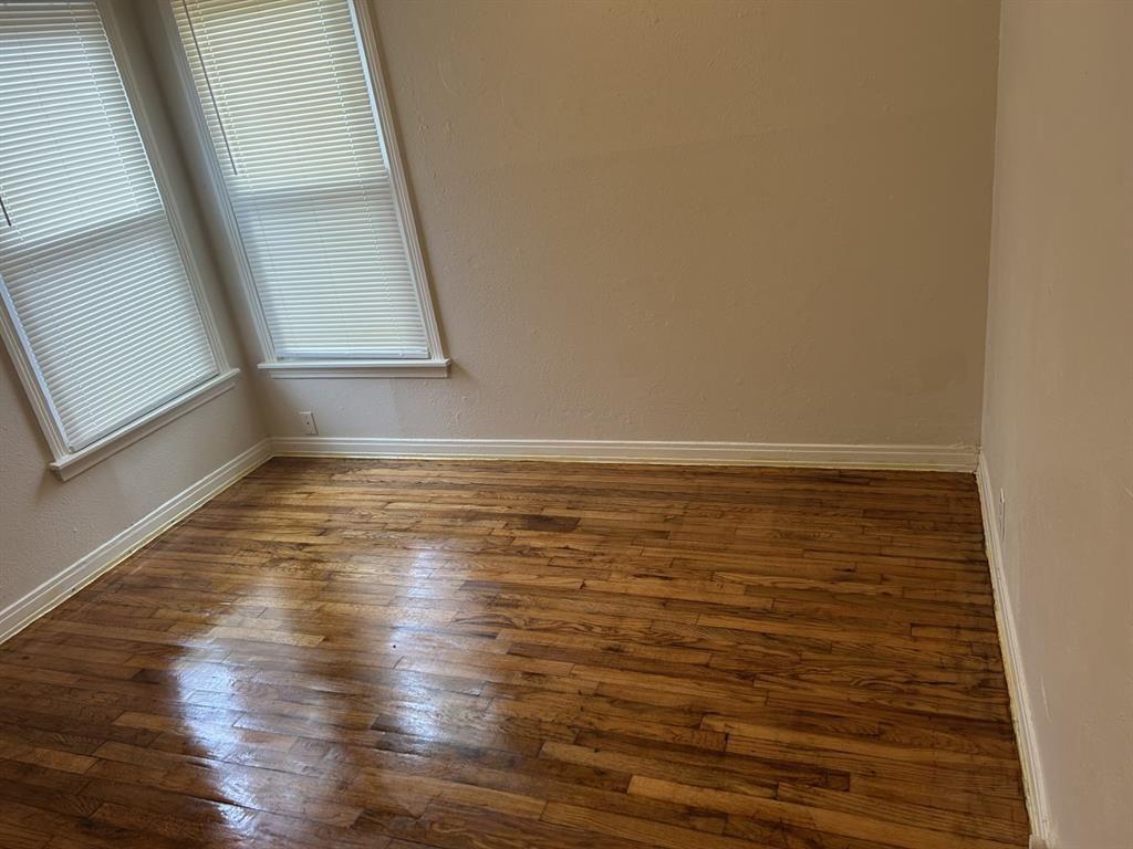 6318 Belgrade Avenue Dallas, TX 75227 - Photo 14 of 23 a view of an empty room with wooden floor and a window