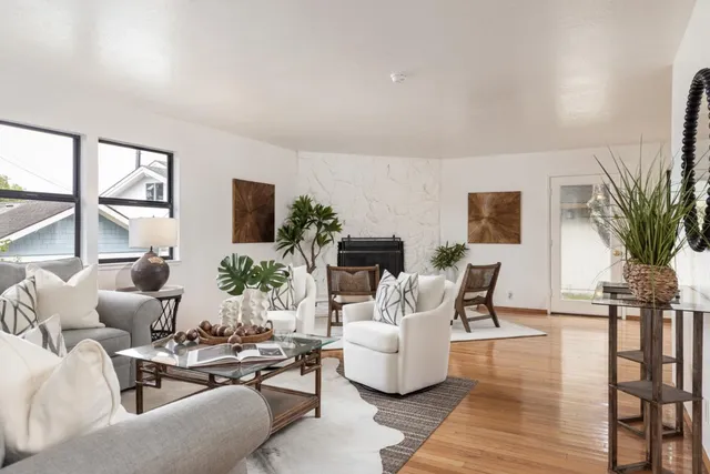 a living room with fireplace furniture and a large window
