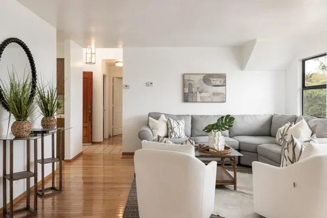 a living room with furniture and a floor to ceiling window
