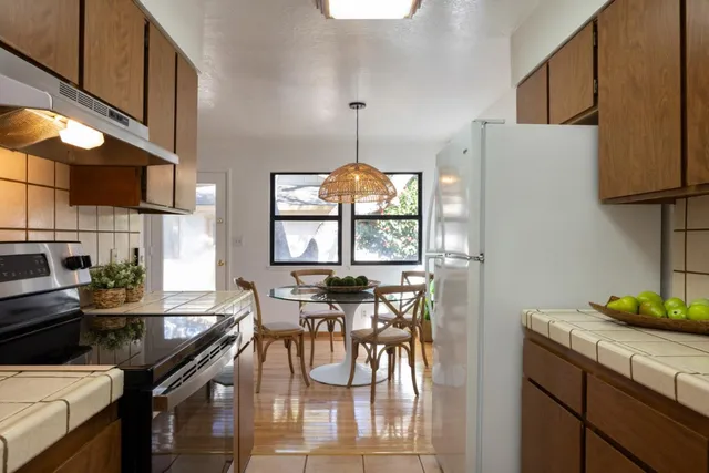 a kitchen with stainless steel appliances a table chairs and a refrigerator