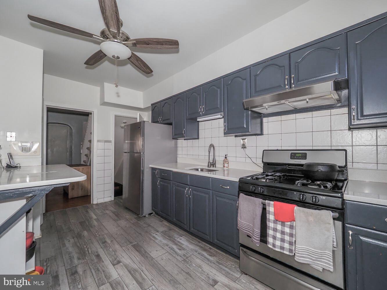 1540 Lochwood Road Baltimore, MD 21218 - Photo 12 of 46 a kitchen with stainless steel appliances a stove cabinets and wooden floor