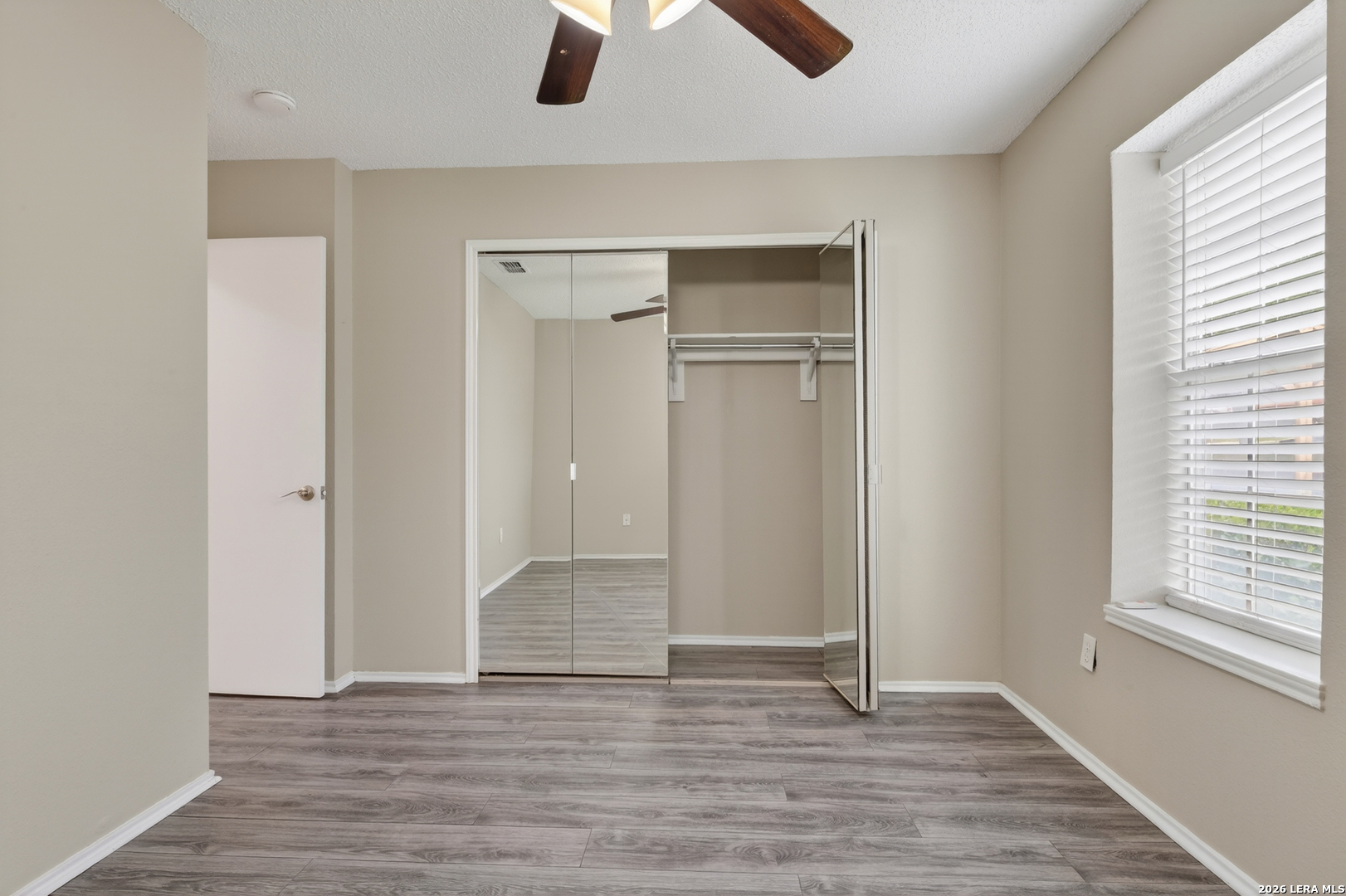 10254 Dover Ridge, Unit 806 San Antonio, TX 78250 - Photo 12 of 16 an empty room with wooden floor cabinet and windows