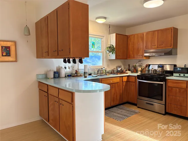 a kitchen with stainless steel appliances granite countertop a sink stove and cabinets