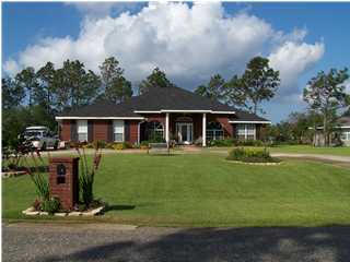 2549 Crescent Road Navarre, FL 32566 - Photo 1 of 22 a front view of a house with a garden