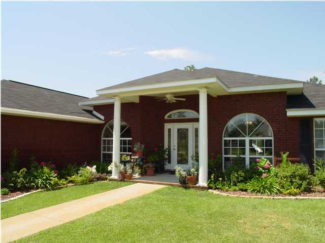2549 Crescent Road Navarre, FL 32566 - Photo 2 of 22 a front view of a house with a garden