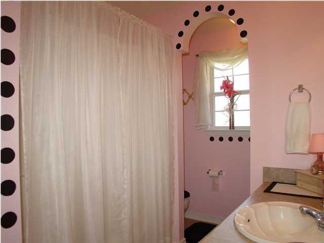 2549 Crescent Road Navarre, FL 32566 - Photo 21 of 22 a bathroom with a sink a toilet and shower curtain