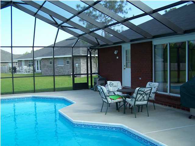 2549 Crescent Road Navarre, FL 32566 - Photo 6 of 22 a view of a patio with couches table and chairs and potted plants