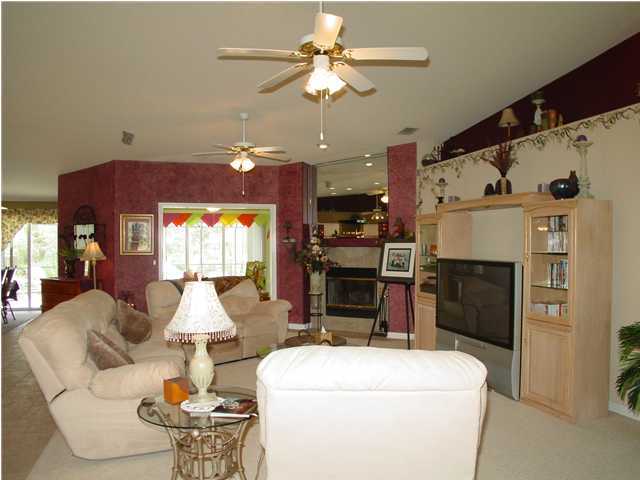 2549 Crescent Road Navarre, FL 32566 - Photo 8 of 22 a living room with furniture a fireplace and a chandelier