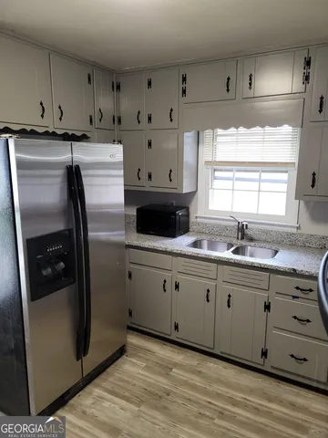 a kitchen with granite countertop white cabinets and stainless steel appliances