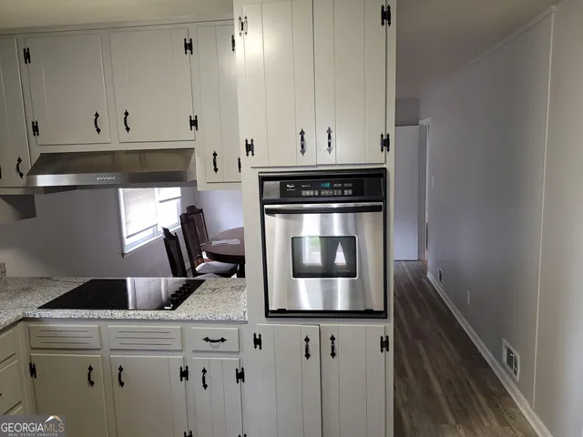 a kitchen with a stove and white cabinets