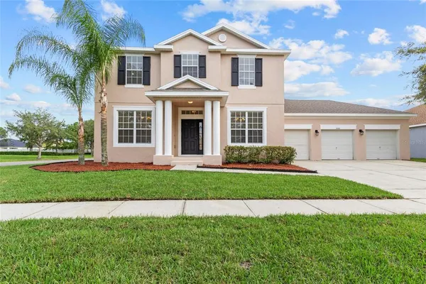 a front view of a house with a garden and yard