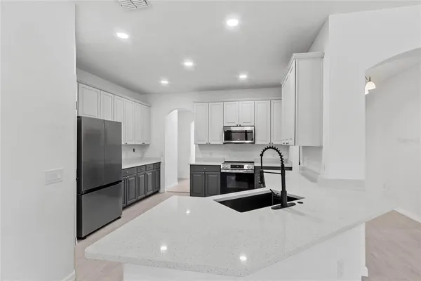 a kitchen with stainless steel appliances granite countertop a refrigerator stove and sink