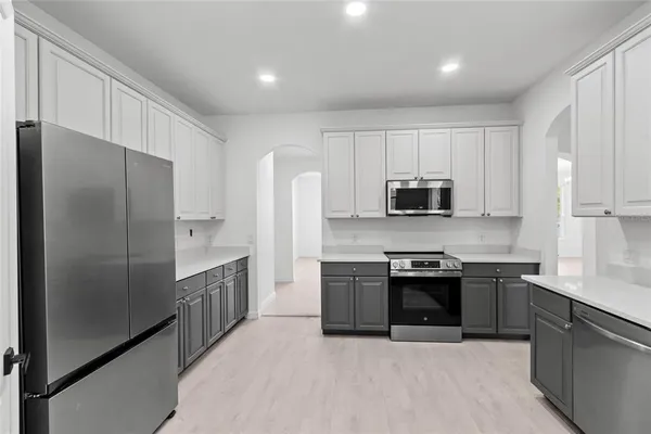 a kitchen with stainless steel appliances granite countertop a stove top oven a sink and dishwasher with wooden floor