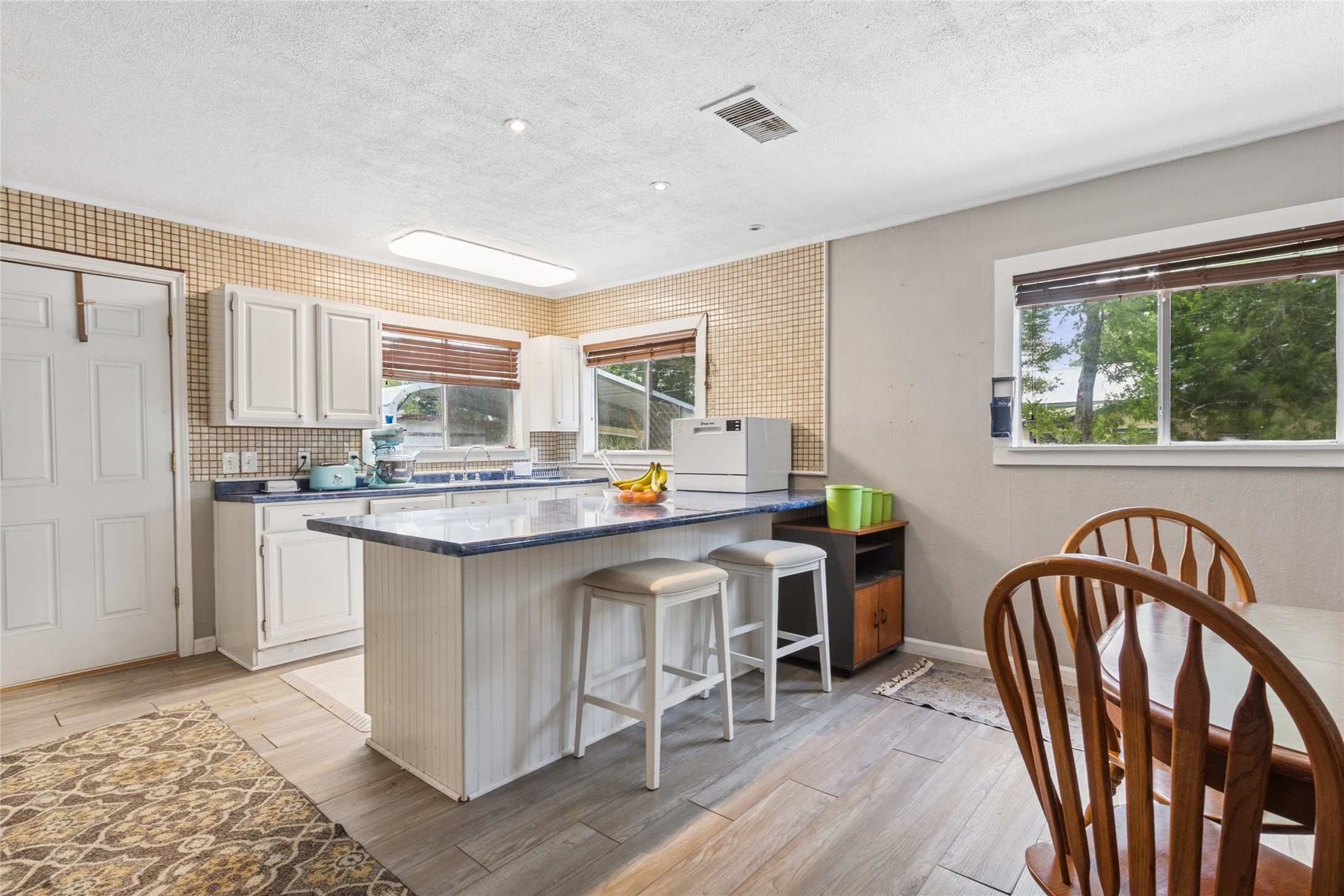 4820 Palmetto Street Bacliff, TX 77518 - Photo 11 of 22 a kitchen with stainless steel appliances granite countertop a table chairs in it and wooden floors