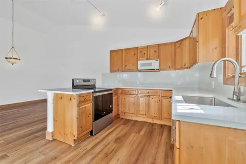 a kitchen with a sink a stove and cabinets