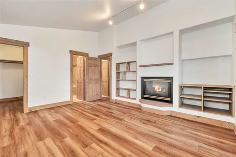 a view of empty room with wooden floor and fireplace