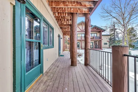a view of a brick house with wooden floor and fence
