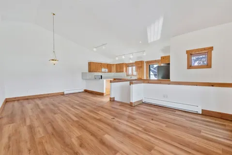 a view of a kitchen with wooden floor and electronic appliances
