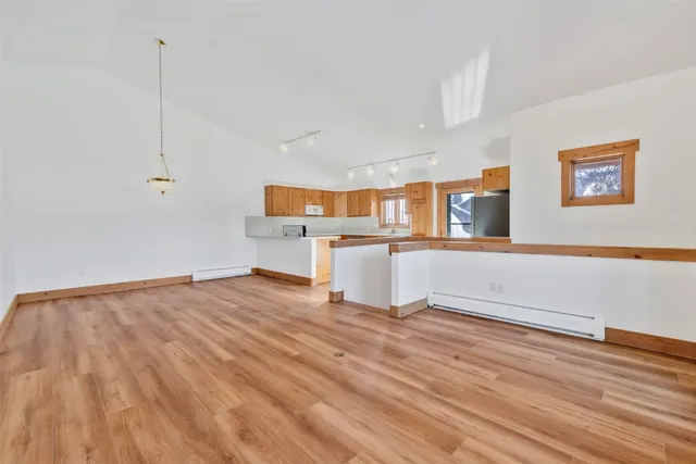 a view of a kitchen with wooden floor and electronic appliances