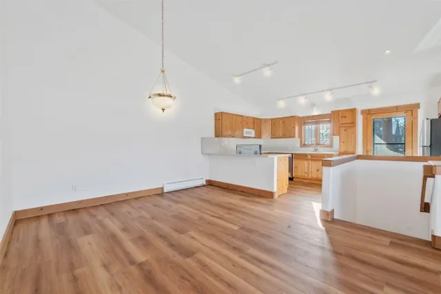 a view of kitchen and hall with wooden floor